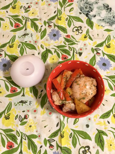 patterned tea towel with candle and bowl with chicken meal