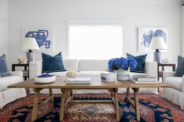 patterned family room carpet ideas with vintage rug, white couch, and blue pillows