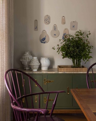dining room with purple chairs and sage green cabinet