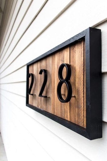 modern DIY house number sign with wood background and black frame