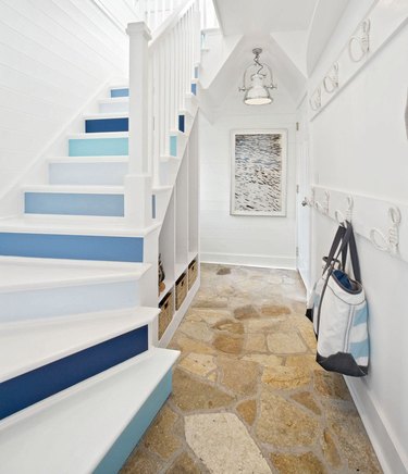 blue and white ombre stair wallpaper on risers of white staircase