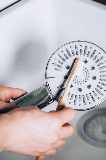 Scrub showerhead with toothbrush