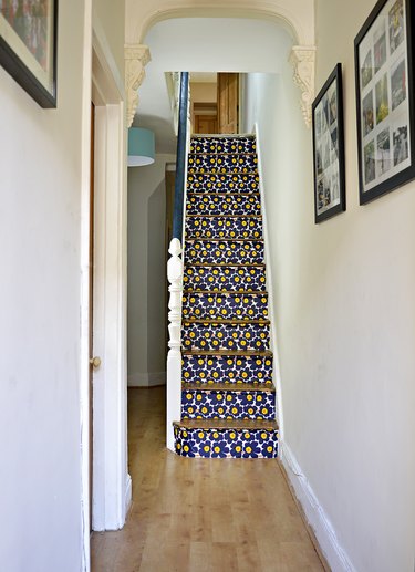 white staircase with marimekko stairs wallpaper on risers and wood treads
