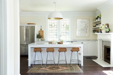 White kitchen design with dome shaped pendant and bar seating