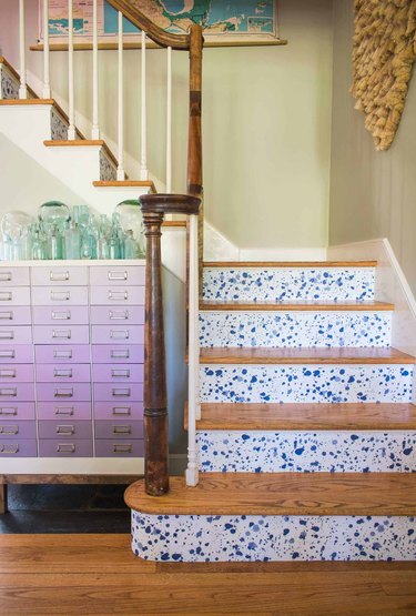 splatter stairs wallpaper on risers of staircase with wood treads