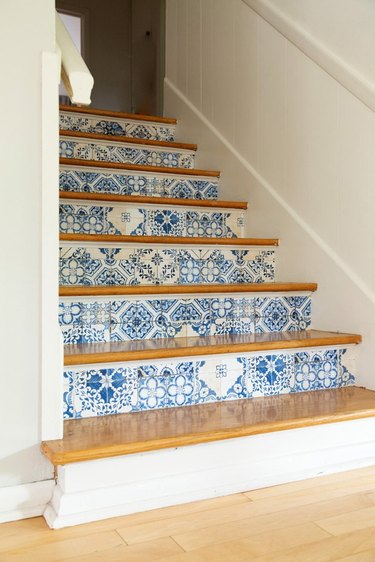 white staircase with blue and white stairs wallpaper on risers