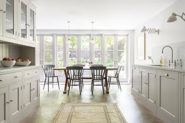 traditional home decor in kitchen with greige cabinets and marble countertops and backsplash