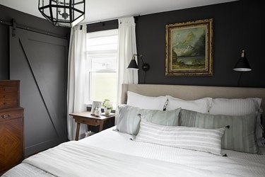 Vintage-inspired dark gray bedroom idea with upholstered headboard and sliding barn door