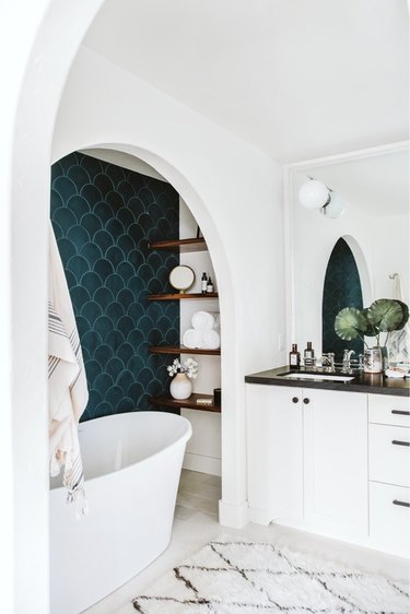 white bathroom with teal shower tile wall in an alcove