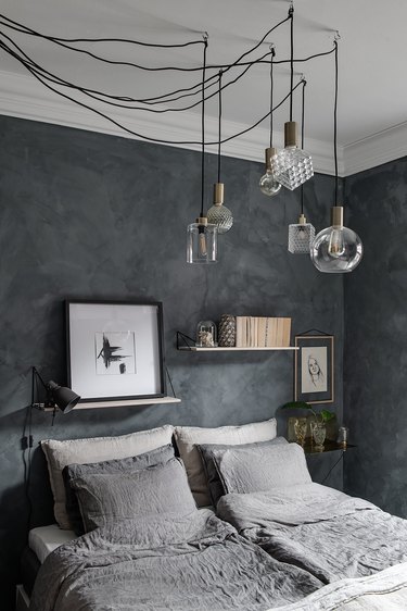 Dark gray bedroom idea with suspension lighting and open shelving
