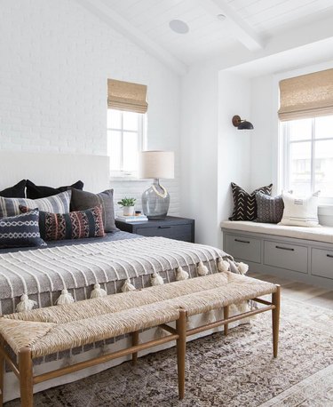 Modern gray bedroom idea with layers of textiles and an accent bench