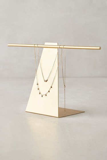 A triangular metronome-like jewelry stand.