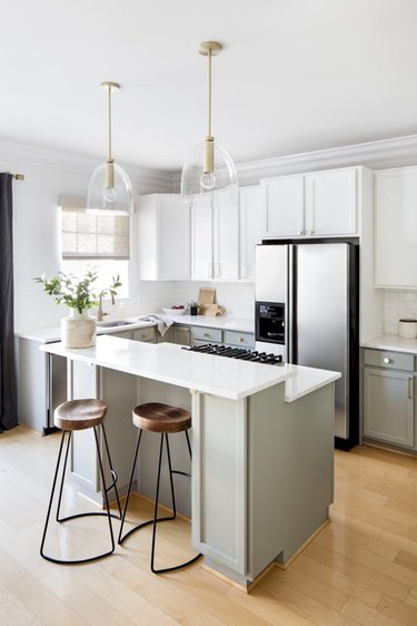 Small kitchen with two clear pendant lights over kitchen island.