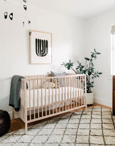 Gender-neutral nursery with white and beige organic color palette and black abstract mobile and artwork