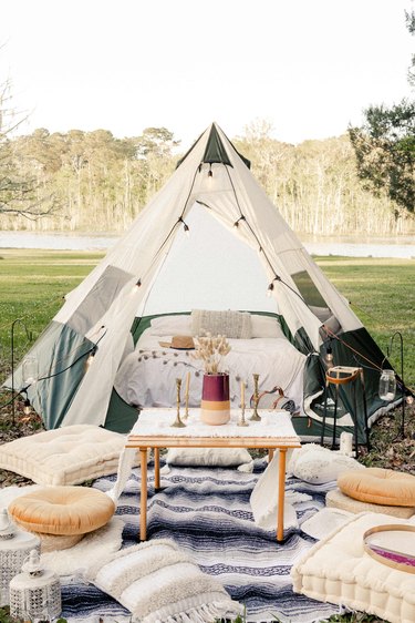 Glamping tent with table, poufs, pillows and blankets