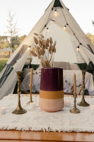 Burgundy, gold and blush striped vase with dried florals and brass candlesticks