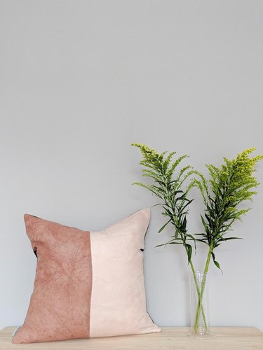 two-toned pillow with greenery nearby