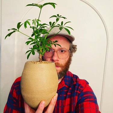 man holding vase with plant