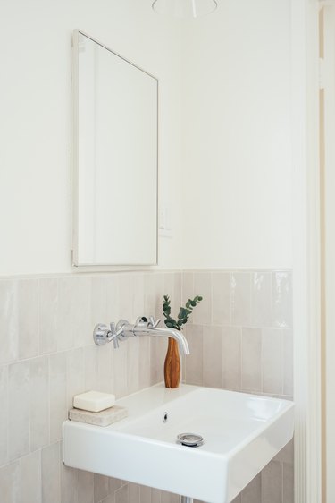 bathroom, wall-mounted silver faucet, white pedestal sink, pink vertical wall tile, rectangular mirror