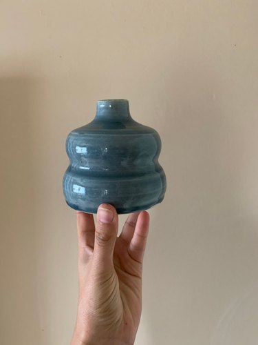 hand holding blue vase