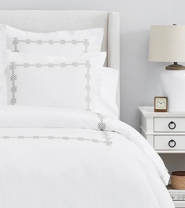 bed with white sheets and white night stand