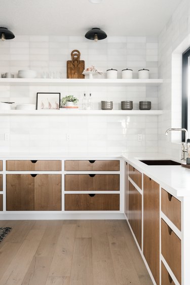 Kitchen lighting idea with open shelving and wood cabinets paired with white subway tile