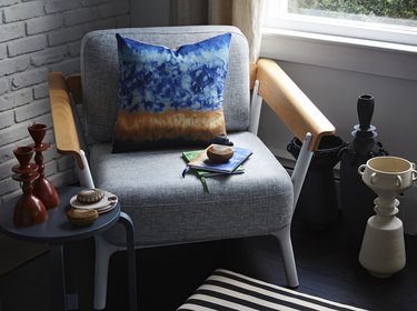 gray chair with blue pillow and decorative objects nearby