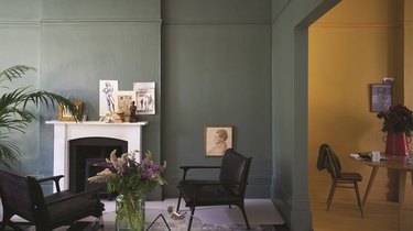 living room with dark green walls and white fireplace