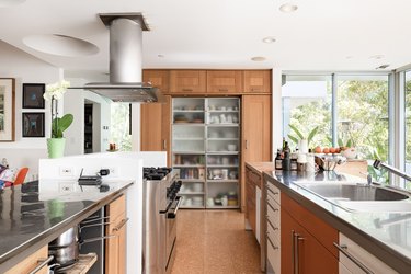 kitchen with cork flooring, tall wooden cabinetry, floor-to-ceiling windows