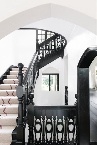 intricate cut out spindles on black stair railing