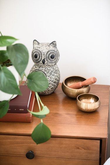 meditation bowls on wood table with ceramic owl