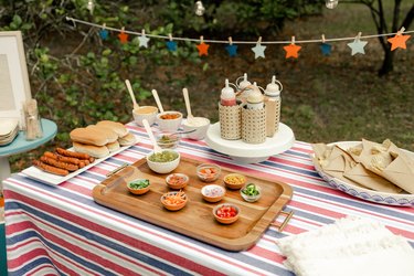 Overhead view of hot dog bar with bowls of gourmet toppings