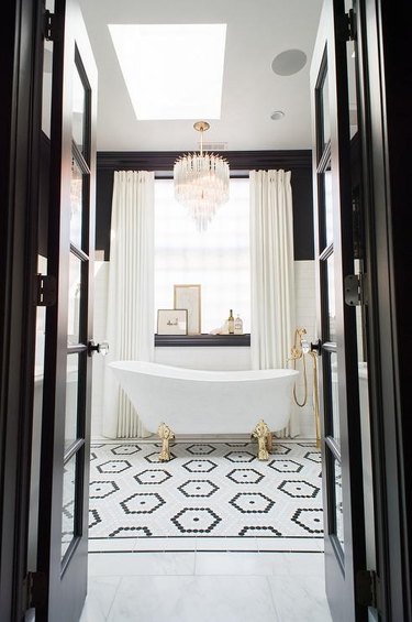 art deco decorating on a budget with clawfoot bathtub in black and white bathroom