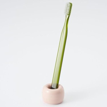 pastel minimalist bathroom toiletries with porcelain toothbrush stand