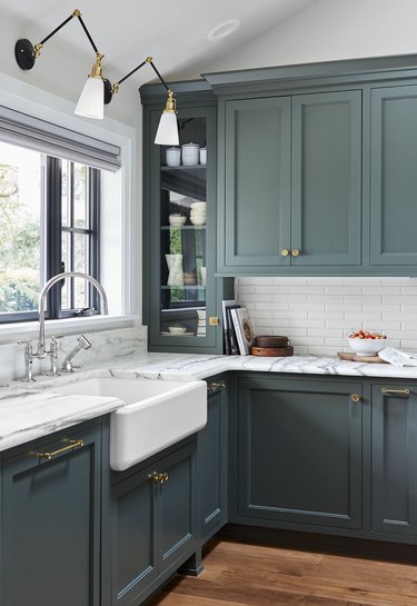 green kitchen cabinet hardware idea with brass pulls and marble countertops