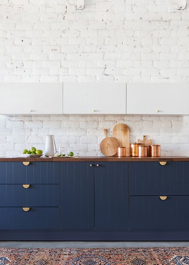 kitchen cabinet hardware idea with blue cabinets and whitewashed brick walls