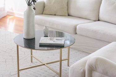 Coffee table with gold painted legs and green faux marble top.