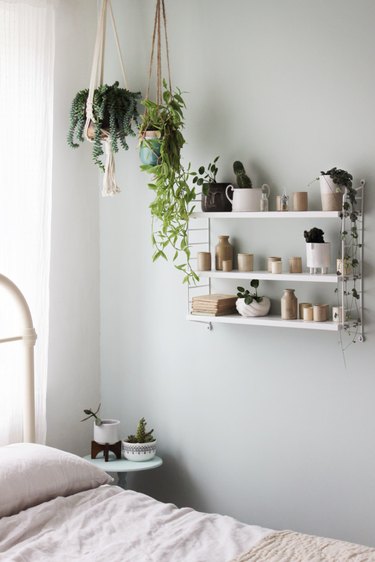 ceramic collection on a hanging self aboe a bed