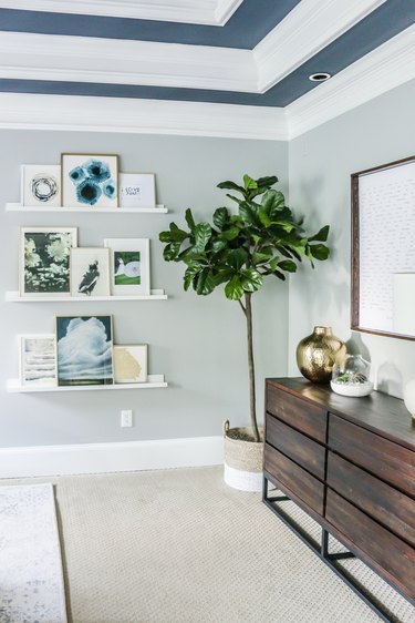 blue bedroom shelving idea with gallery wall and painted ceiling