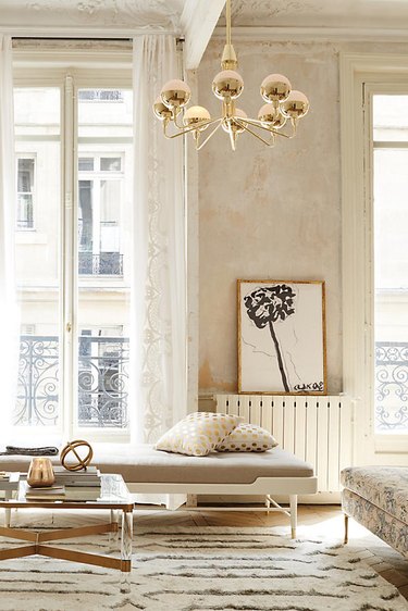 daybed in the living room idea with a white metal daybed with a beige cushion in a warm white and gold room