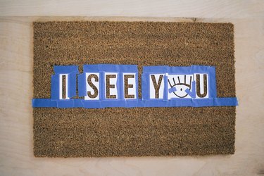 Letter stencils taped to doormat