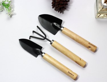 Set of three black gardening tools with wooden handles