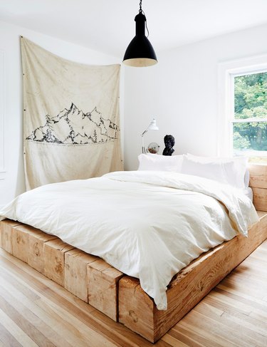 black and white bedroom idea with rustic platform bed an black pendant light