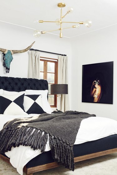 black and white bedroom idea with upholstered headboard and brass chandelier