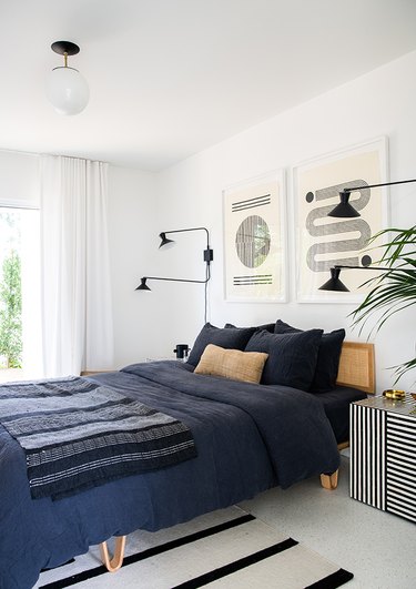 black and white bedroom idea with graphic striped prints and navy blue accents