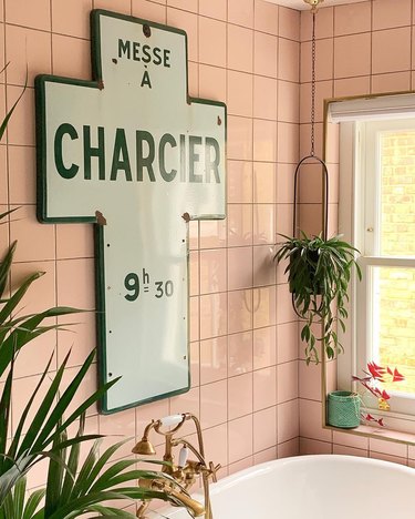 bathroom design idea with pink wall tile and vintage church sign