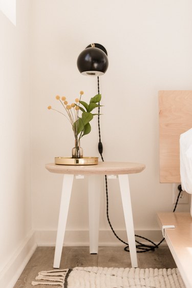birch side table with white metal legs and flowers in vase