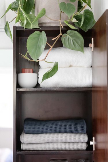 bathroom linen cabinet full of towels