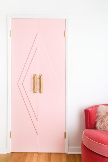 Art deco door in pink with geometric accents and brass handles