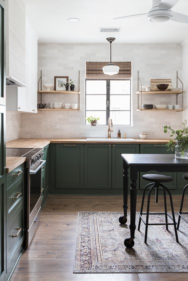 Traditional kitchen design with green cabinets and white tile backsplash